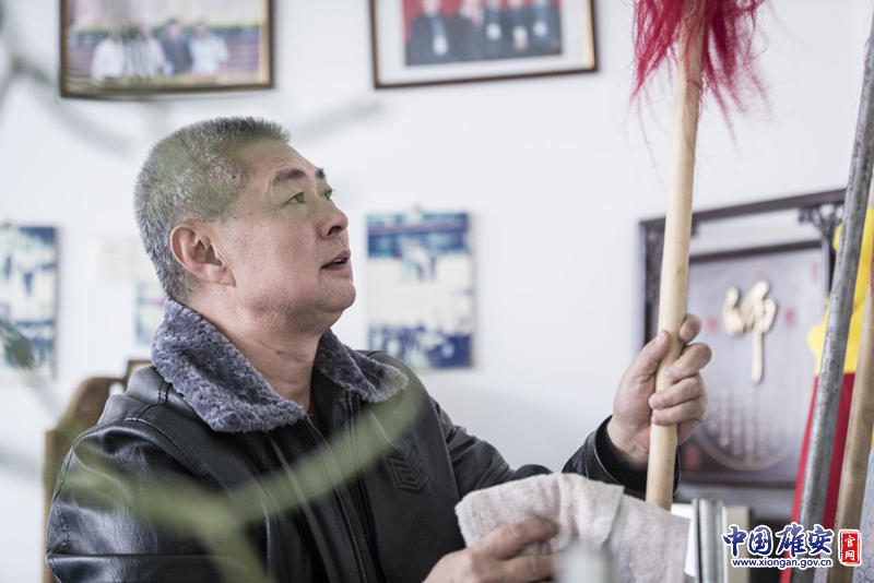 陳桂學擦拭著練功房中的兵器，這些兵器很多是父輩們留下來的。李鑫 攝